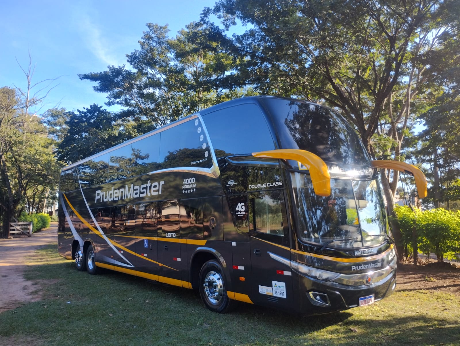 Ônibus Pruden Master 4000 Premium estacionado em área arborizada