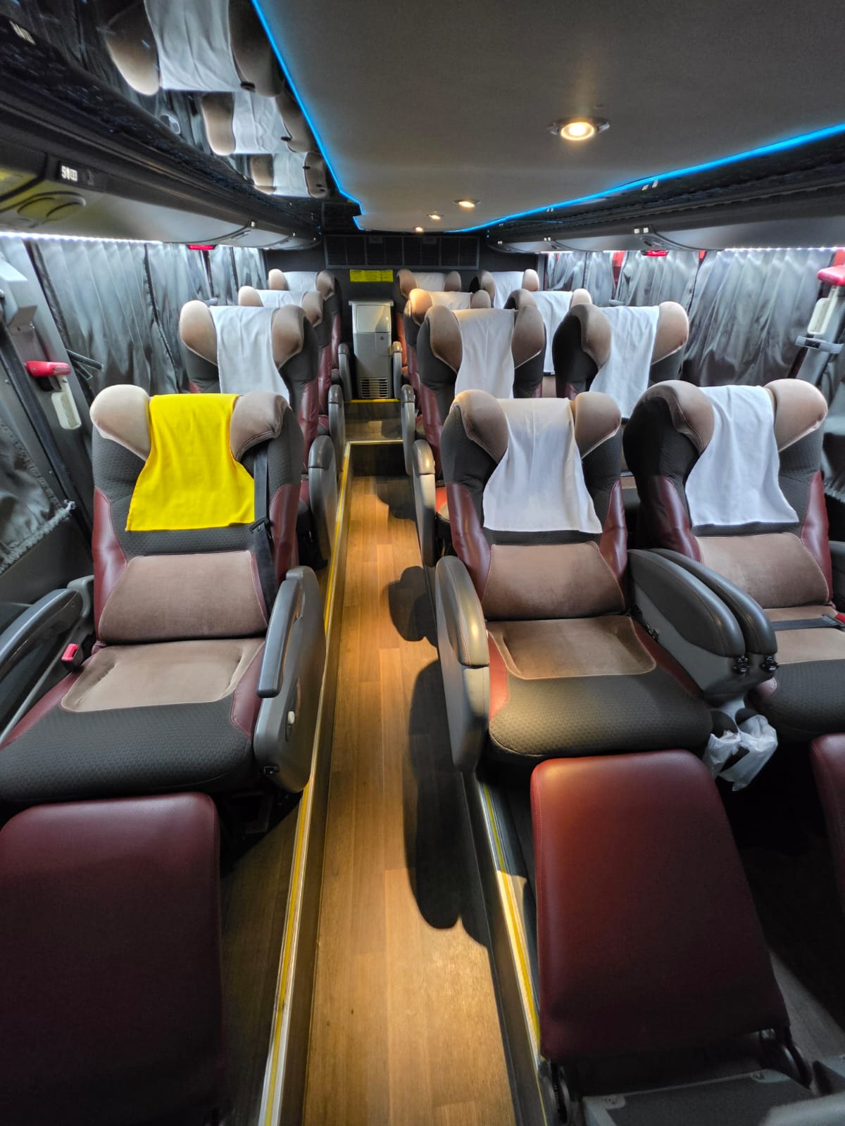 Interior com poltronas leito e piso em madeira